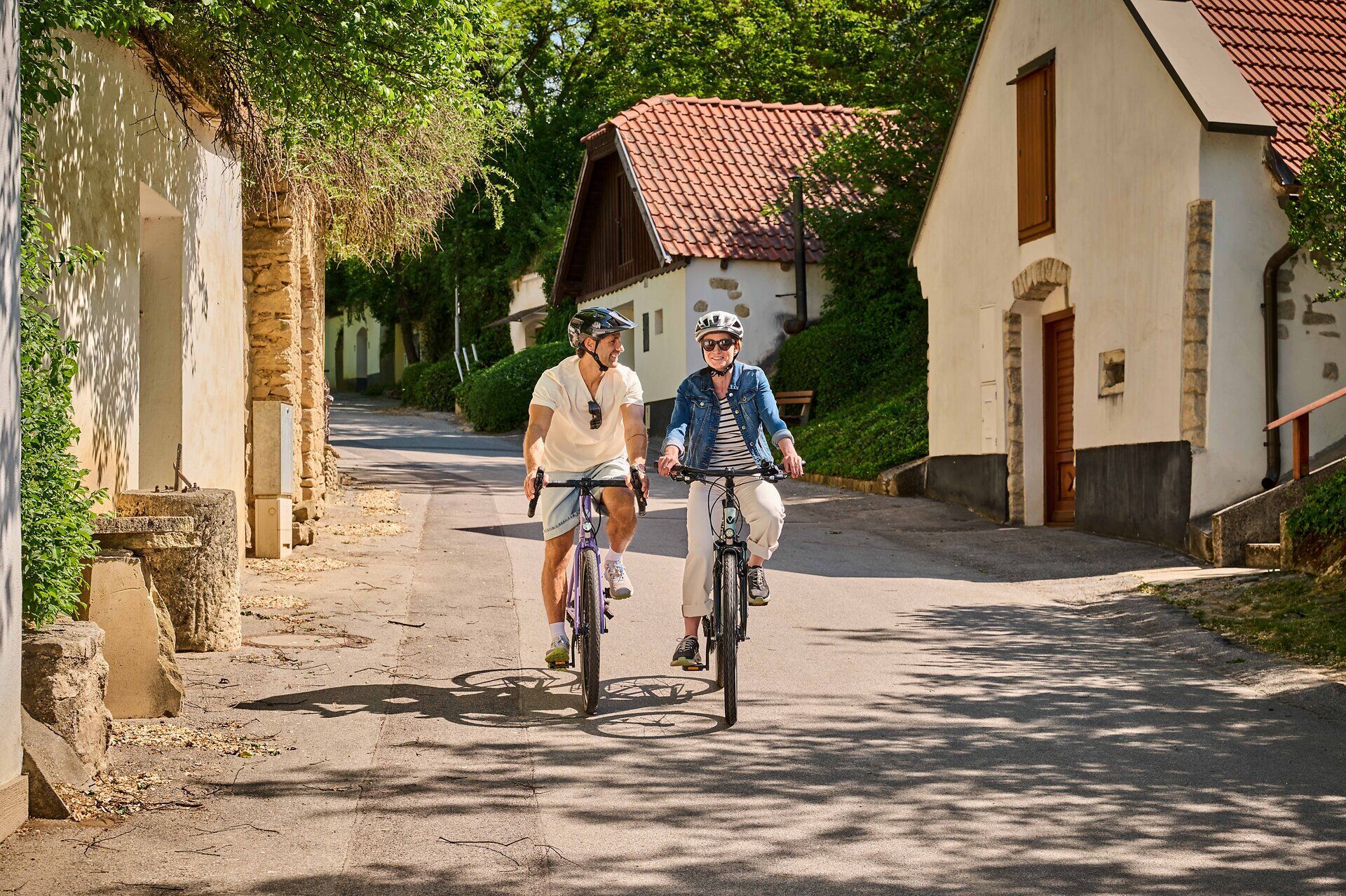 Ein Mann und eine Frau mit ihren Fahrrädern in der Kellergasse von Stixneusiedl.