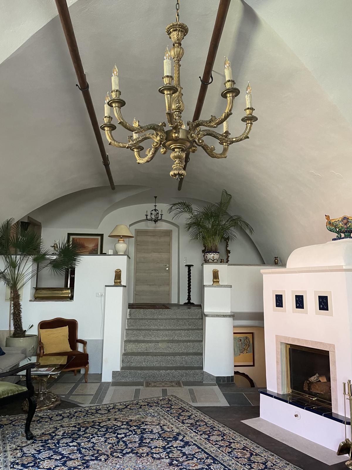 Eleganter Raum mit Kronleuchter, Kamin und Treppe.