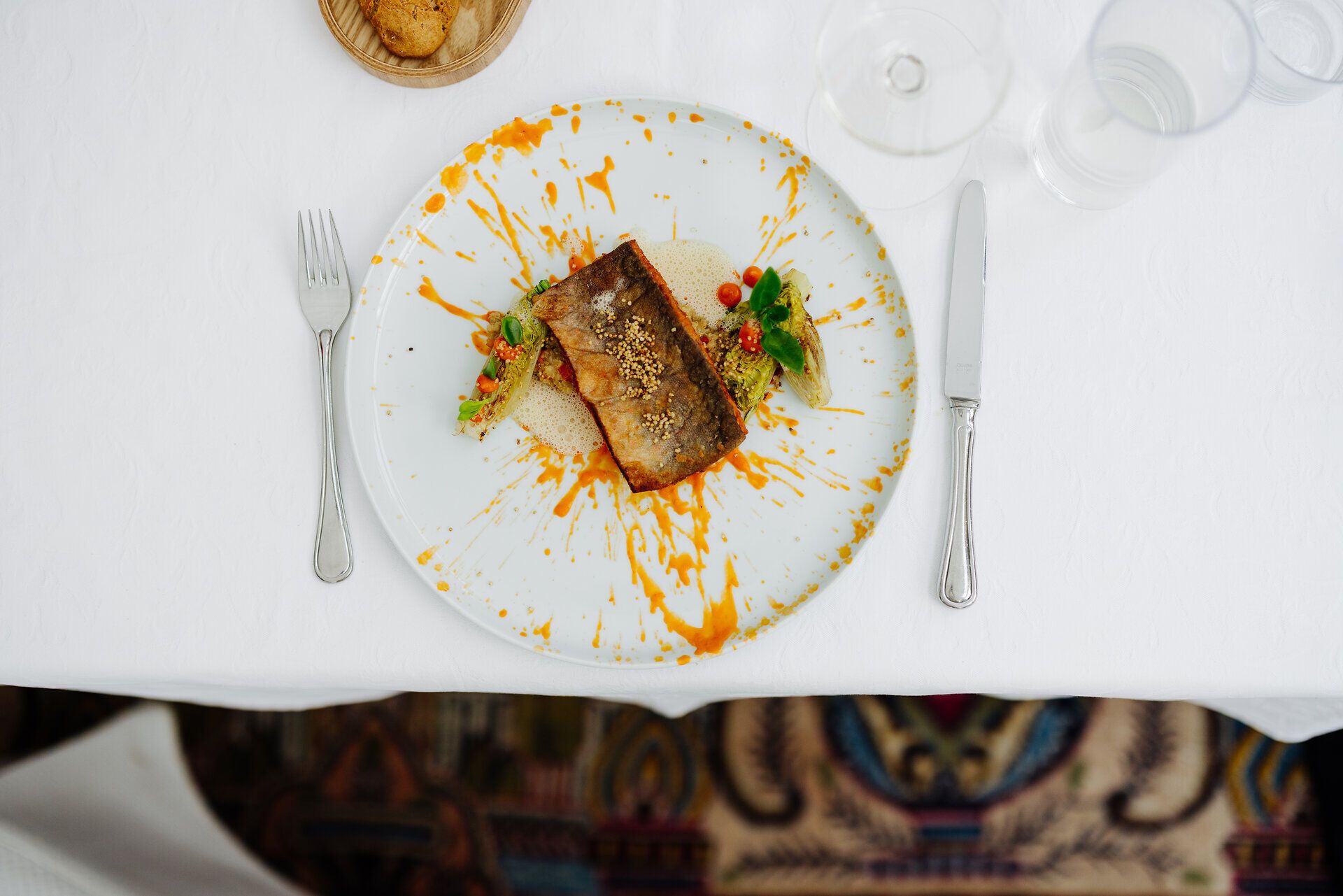 Ein köstlicher gebratener Alpenlachs, kunstvoll angerichtet auf einem Bett aus Quinoa, verspricht ein unvergessliches Geschmackserlebnis. Die leuchtenden Farben der Sauce und frischen Kräuter verleihen dem Gericht eine einladende Note, die zum Genießen einlädt. Hier in der malerischen Umgebung wird jede Mahlzeit zu einem Fest für die Sinne.