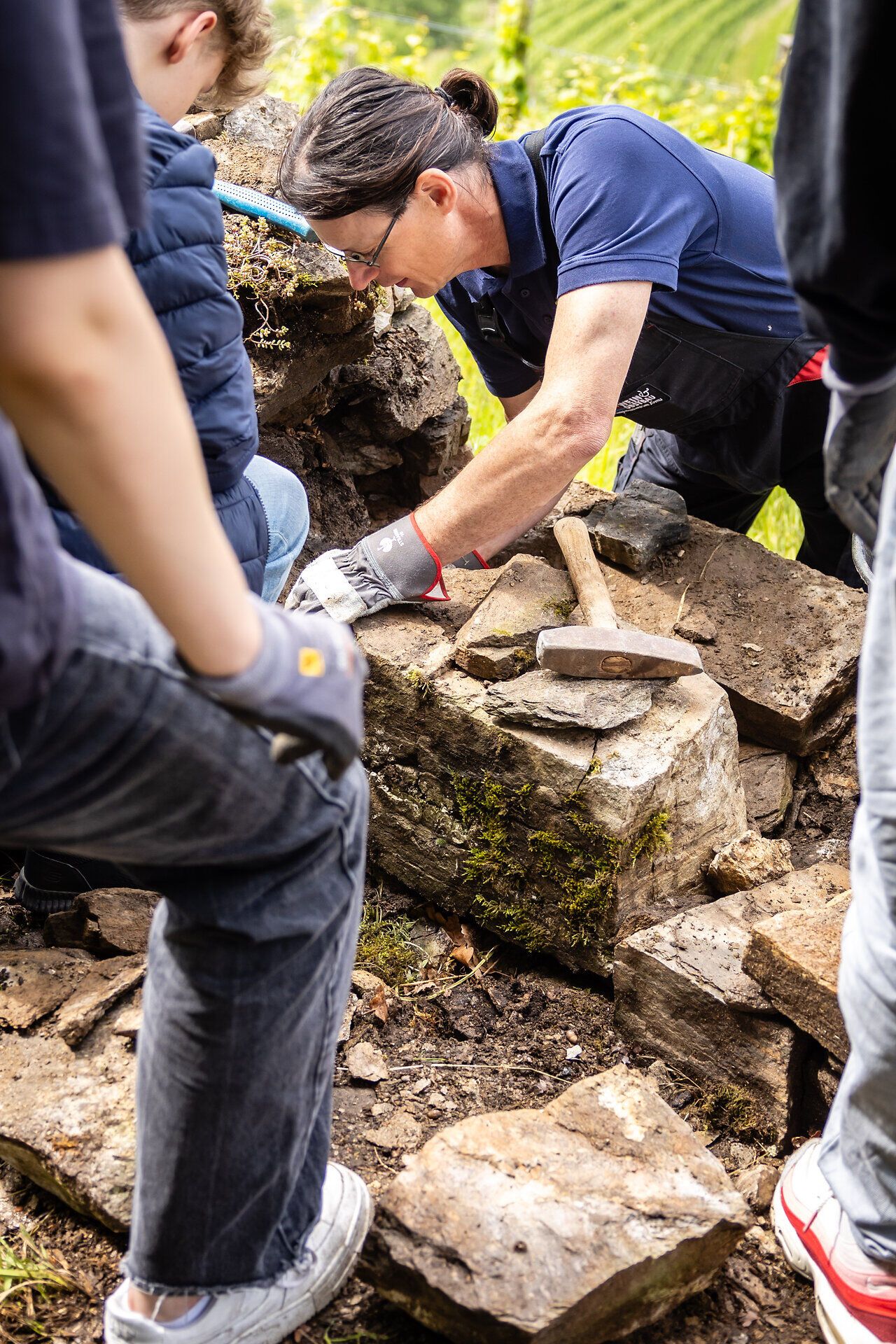 Männer in blauen Arbeitsgewand beim Trockensteinmauern