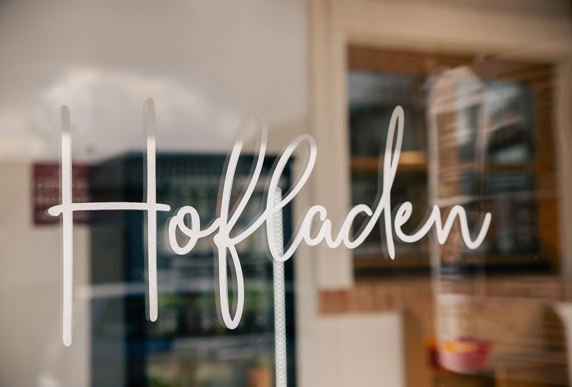 Schriftzug "Hofladen" auf einer Glasscheibe. 