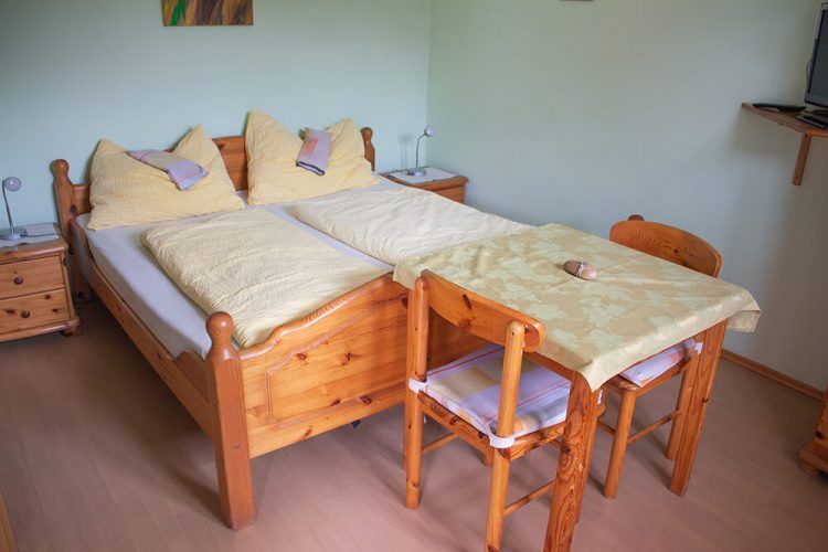 Schlafzimmer mit Holzmöbeln und Doppelbett.