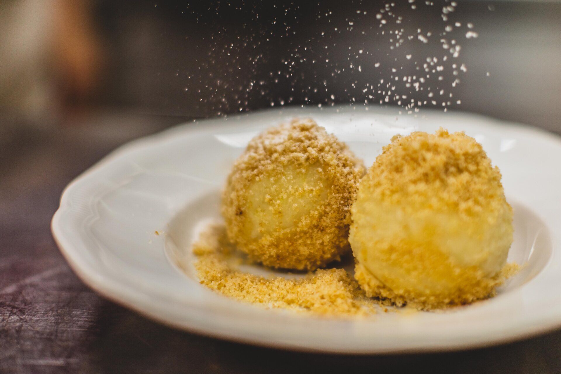 Zwei köstliche Marillenknödel, liebevoll mit einer knusprigen Bröselkruste umhüllt, laden zum Genießen ein. Der süße Duft von frischen Aprikosen und der Hauch von Zucker versprechen einen unvergesslichen Sommergenuss. Perfekt für eine entspannte Auszeit in der Wachau.