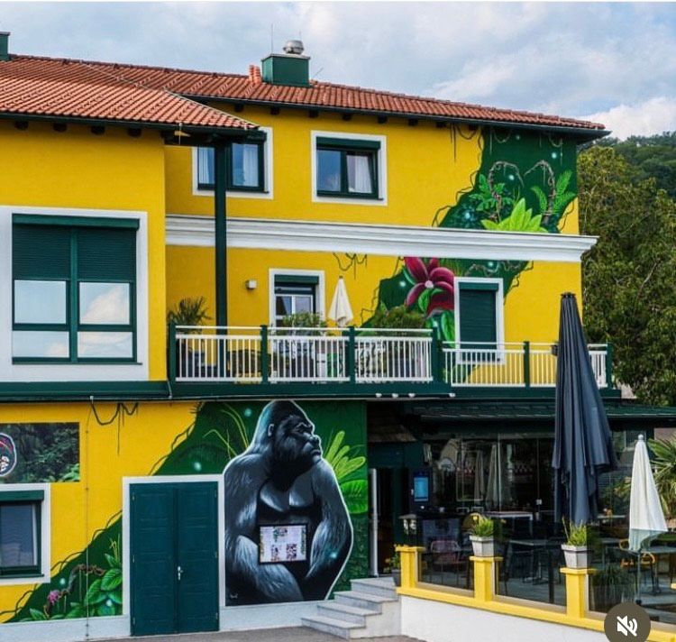 Yellow building with gorilla murals and jungle motifs.