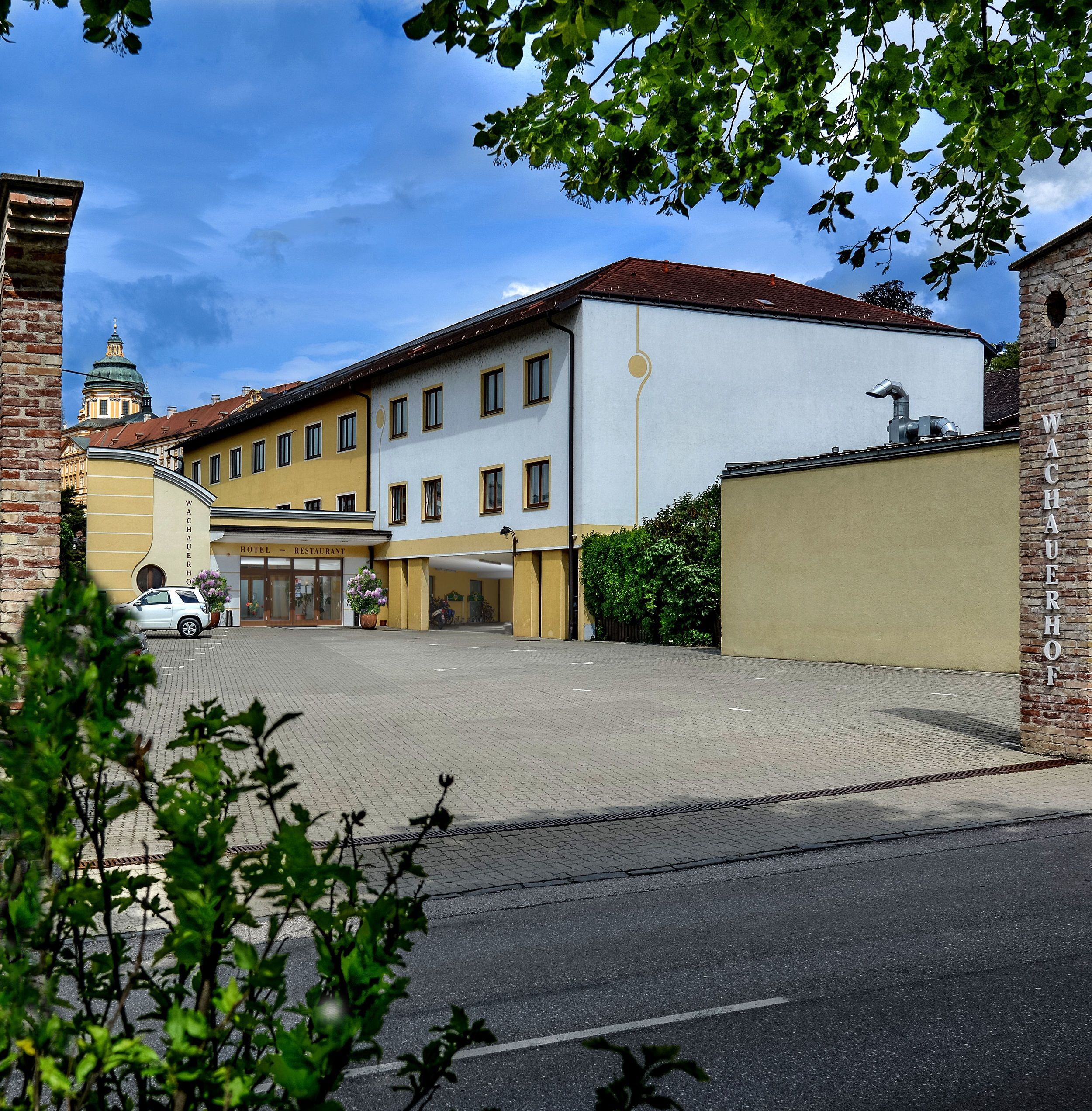 Außenansicht des Wachauerhofs in Melk mit Parkplatz und Gebäudefassade.